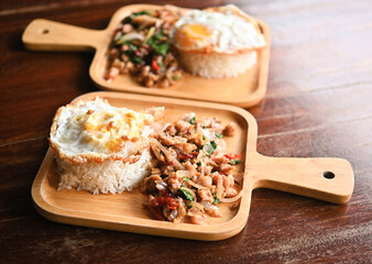 Stir-fried pork with basil, fried egg rice, Thai food, Thai food, the food on the wooden plate looks good and tastes good.