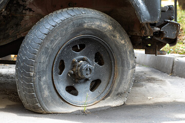 Fototapeta na wymiar Old and flat car tire.