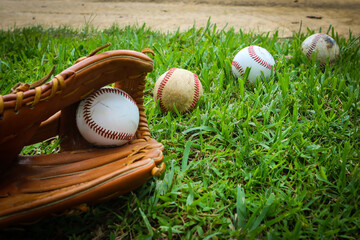 Close-up of Baseball Equipment including baseball glove and balls in the grass at park in Central Florida