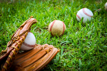 Close-up of Baseball Equipment including baseball glove and balls in the grass at park in Central Florida