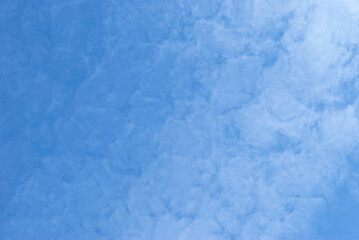 Gentle white clouds in a bright blue sky