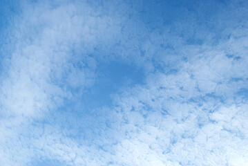 Gentle white clouds in a bright blue sky