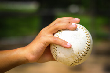Close-up of person holding softball hand closed on ball from side in Central Florida