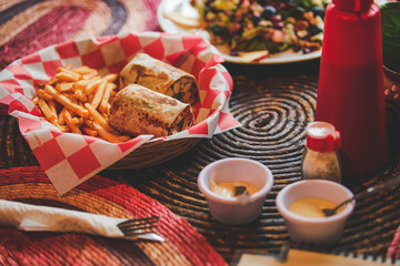 Restaurant fast food. Chicken, cheese, and avocado burrito with fries