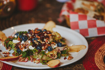 Restaurant fast food. Red fruit salad with lettuce, apple, cheese, almonds, blueberry, food with friends, eating on the go.