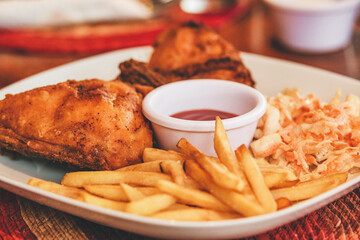 Restaurant fast food. Fried chicken with salad and French fries with dressing.