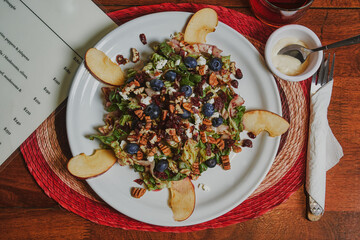 Restaurant fast food. Red fruit salad with lettuce, apple, cheese, almonds, blueberry, food with friends, eating on the go.