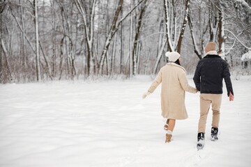 Fototapeta na wymiar Portrait of romantic couple spending time together in forest at winter day
