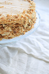 napoleon cake, round whole with caramel cream on a white background. copy space