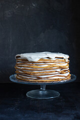 a whole round honey cake on a stand against a dark background - 536442708