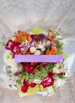 beautiful bright bouquet in a purple basket on a white background, copy space