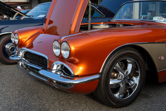 Headlights Of Orange Retro Chevrolet Corvette With Open Car Hood. 1961 Chevy At Car Exhibition. Snohomish, WA, USA - September 2022