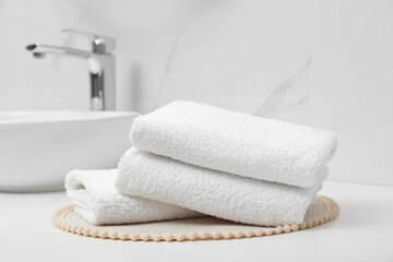 Fototapeta na wymiar Folded bath towels on white table in bathroom