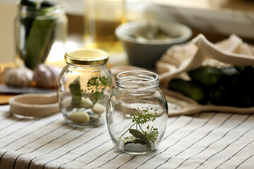 Empty glass jars and ingredients prepared for canning on table