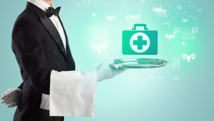 Handsome young waiter in tuxedo holding healthcare icons on tray