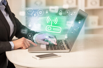 Hands working on laptop with digital icons