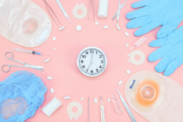 Surgeon's kit for surgery with a watch and a colostomy bag on a soft pink background.