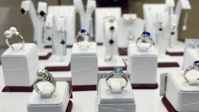 White gold rings with precious stones are in the window of a jewelry store