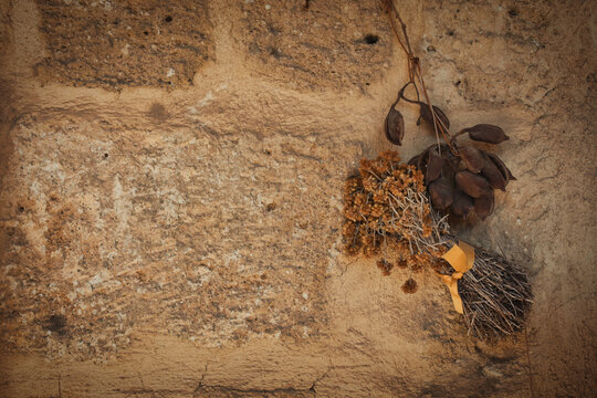 Vintage background of old brick wall with dried flowers and leaves. A bunch of Dried St. John's Wort flower  and dried leaves hung on an stone wall. Autumn wallpaper, copyspace 