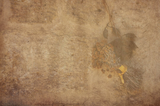Vintage background of old brick wall with dried flowers and leaves. A bunch of Dried St. John's Wort flower  and dried leaves hung on an stone wall. Autumn wallpaper, copyspace 