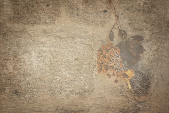 Vintage background of old brick wall with dried flowers and leaves. A bunch of Dried St. John's Wort flower  and dried leaves hung on an old stone wall. Autumn wallpaper