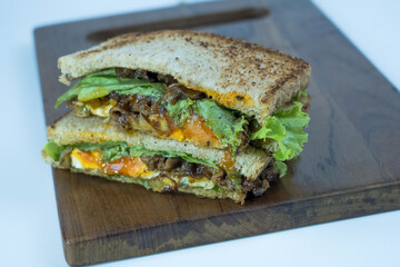 Sandwich on a cutting board. Pieces of appetizing of shortplate beef.
