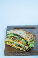 Sandwich on a cutting board. Pieces of appetizing of shortplate beef.