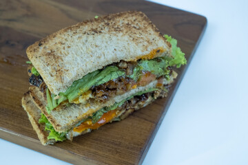 Sandwich on a cutting board. Pieces of appetizing of shortplate beef.