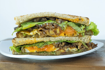 Sandwich on a cutting board. Pieces of appetizing of shortplate beef.