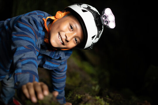 Little boy wearing helmet for caving inside caves