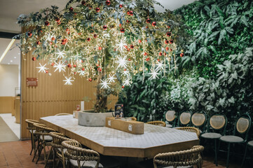 Christmas decration ornamental for family restaurant. Combined artificial red flower, tree and plants. Seasonal decoration. Starry light tree. 
