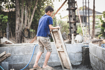 Poor children at the construction site were forced to work. Concept against child labor. The...