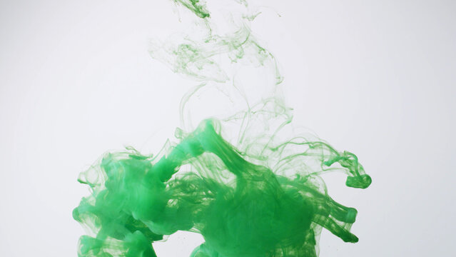 Abstract formed green color dissolving water. Abstract cloud ink swirling water. Royalty high-quality stock photo Acrylic ink underwater form, abstract smoke pattern isolated on white background