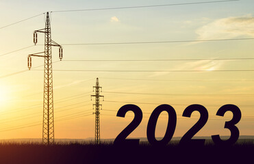 The number 2023 with electric pylons at sunset. Concept of high price of electricity or Happy New...