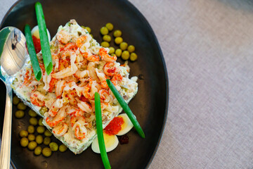 portion salad with shrimp, quail eggs, caviar and canned peas in a plate.