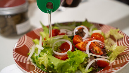 simple salad that consists of a bunch of tomatoes, onion, and lettuce poured with dressing to make it salty