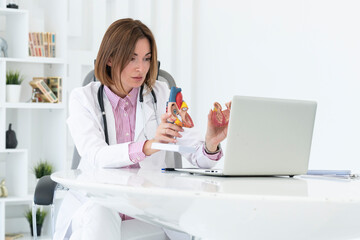 Portrait of young female doctor cardiologist working in office of modern clinic	
