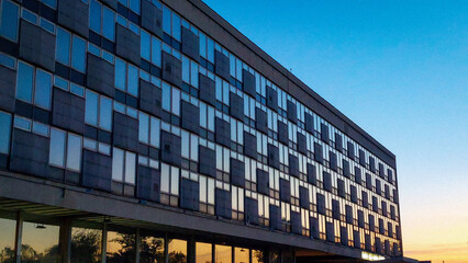 Office building with glass reflections of setting sun