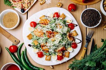 Healthy Caesar salad of chicken with tomatoes and croutons. Restaurant serving dishes on a plate.