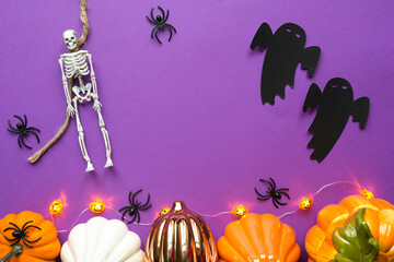 Halloween layout of garland of skeleton on a rope, glowing Jack o Lantern, pumpkins, spiders on a...