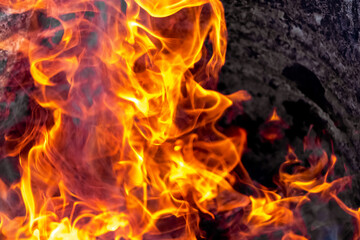 Burning fire close up. Bright orange and red flames on a dark background. Open flame heating. Problems with heating and gas.