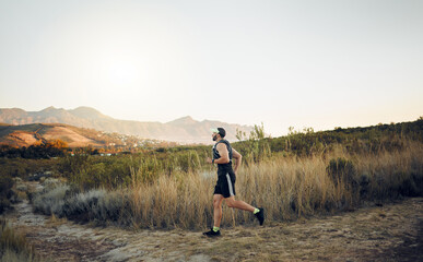 Man running in nature, marathon fitness training exercise and healthy sunrise cardio workout. Sports runner, racing on hiking path and working out for athletic speed or energy in race competition