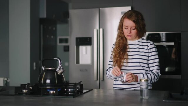 Close up - woman has a heart attack doing coffee, taking pills. Adult female boiling water, feels pain in her chest, takes medicine. Girl cooking dinner and experiences pain in heart, drinks drugs.