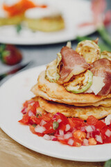 A stack of delicious pancakes with bacon, honey, nuts and caramelized banana. A hearty breakfast.