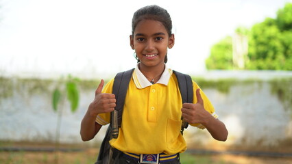 Happy smiling indian schoolgirl in school uniform with backpack bag. Portrait of smart Indian girl kid student.