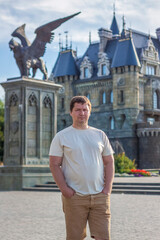Fototapeta premium A man on the background of a Gothic-style castle. The territory of the tourist complex
