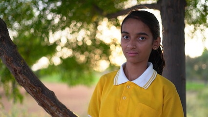 Happy smiling indian schoolgirl in school uniform looking into camera. Portrait of smart Indian...