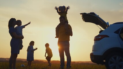 happy family. children stand together next to the car silhouette of the sunset in the park. family dream concept. happy family standing with sunlight, back watching the journey in travel the park