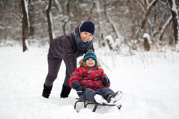 Fototapeta na wymiar Happy mother and baby in winter park