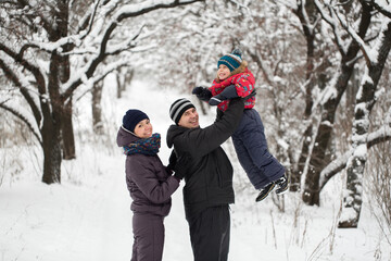 Fototapeta na wymiar Happy family playing in winter forest
